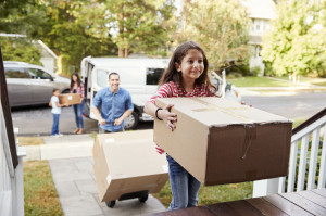 94361320 - children helping unload boxes from van on family moving in day